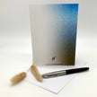 Greeting card with gradient design, pen, and decorative elements on a white background