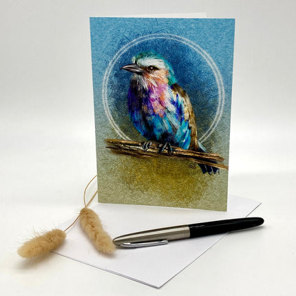 Greeting card with a colorful bird illustration on a blue background, accompanied by a pen and decorative item.