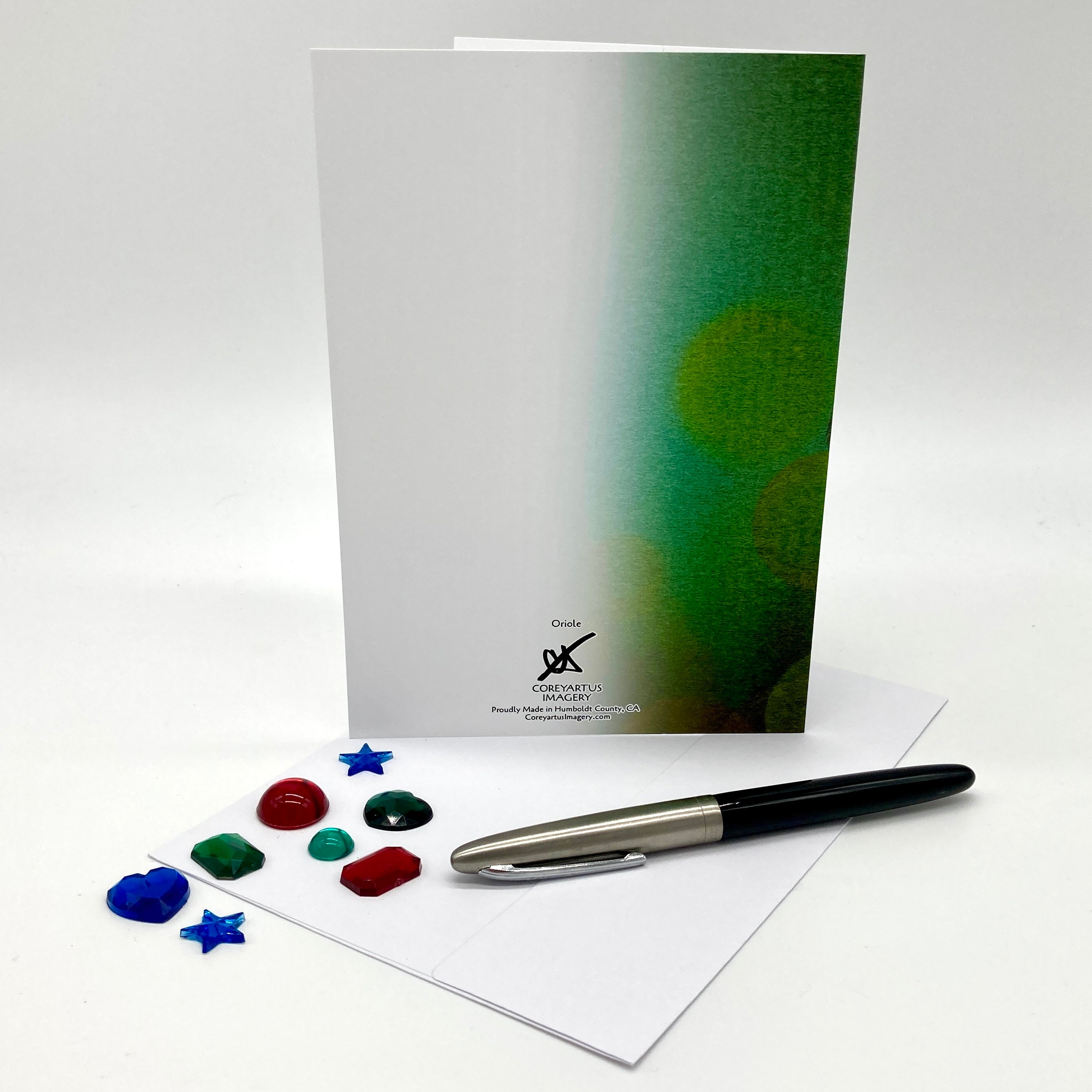 Card with green gradient design, pen, and color swatches on a white background