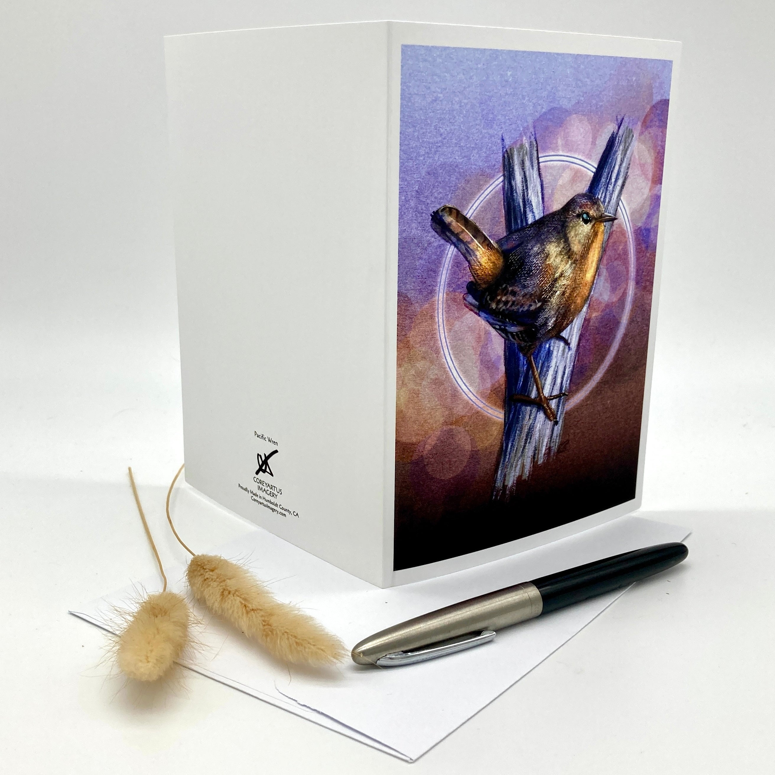 Product photo of the backside of a greeting card splayed out open with a Pacific Wren in browns and purples.