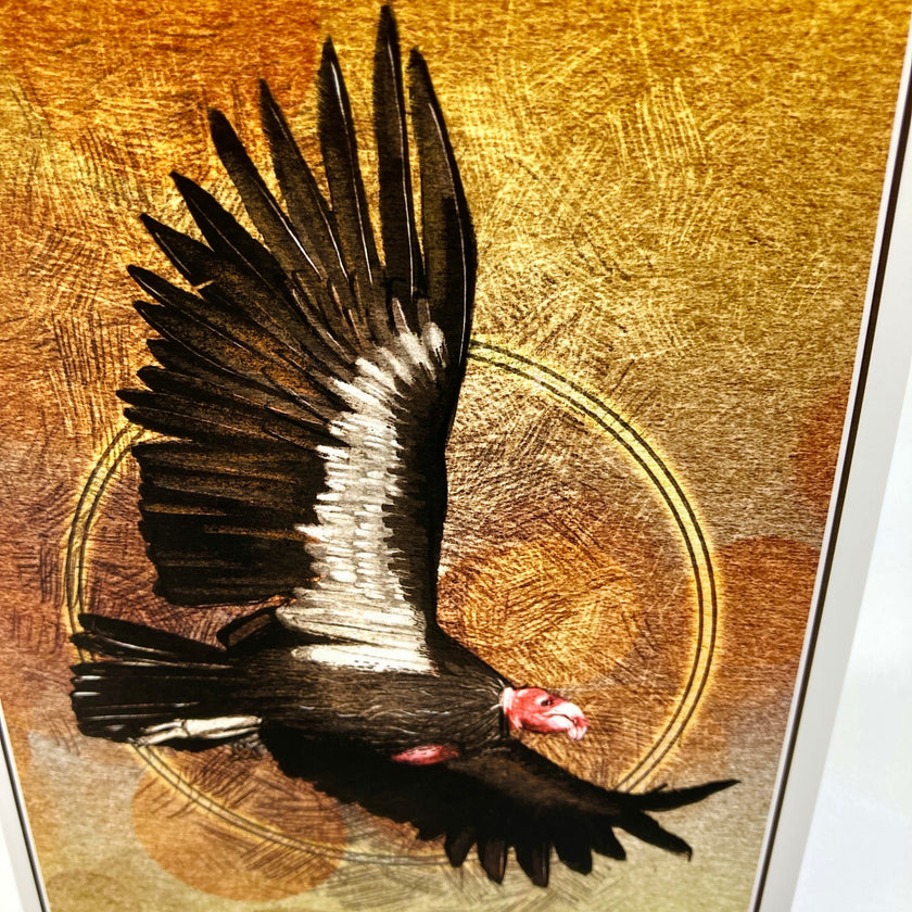 A close-up of a textured art print or painting depicting a black bird of prey with white wing markings and a red head, flying over a circular motif on a metallic gold background.