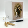 Product photo of a bird greeting card in brown featuring two burrowing pygmy owls on a stump.