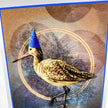 Closeup of a birthday card featuring a marbled Godwit in a blue party hat.