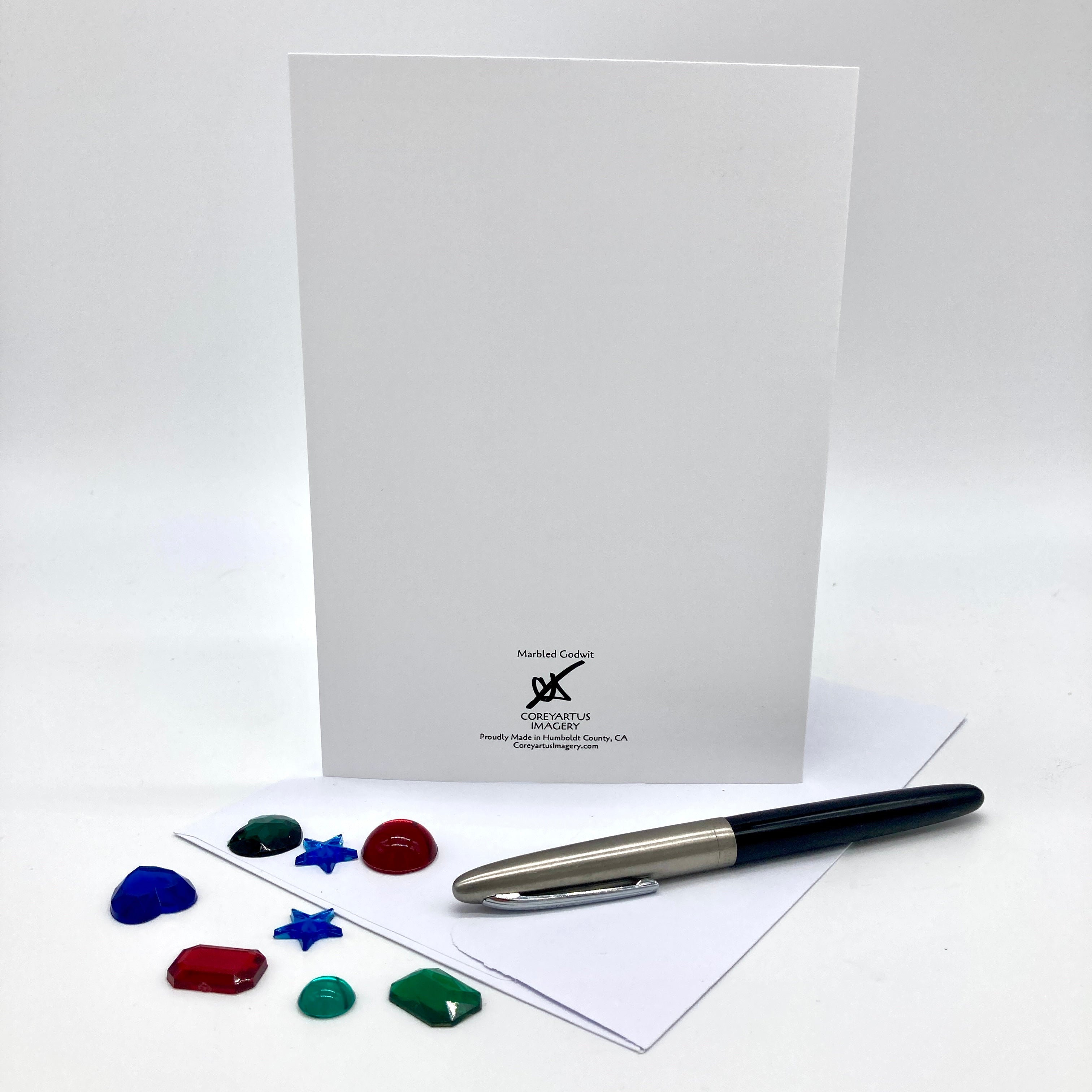 Backside of a greeting card posed with plastic rhinestone shapes.