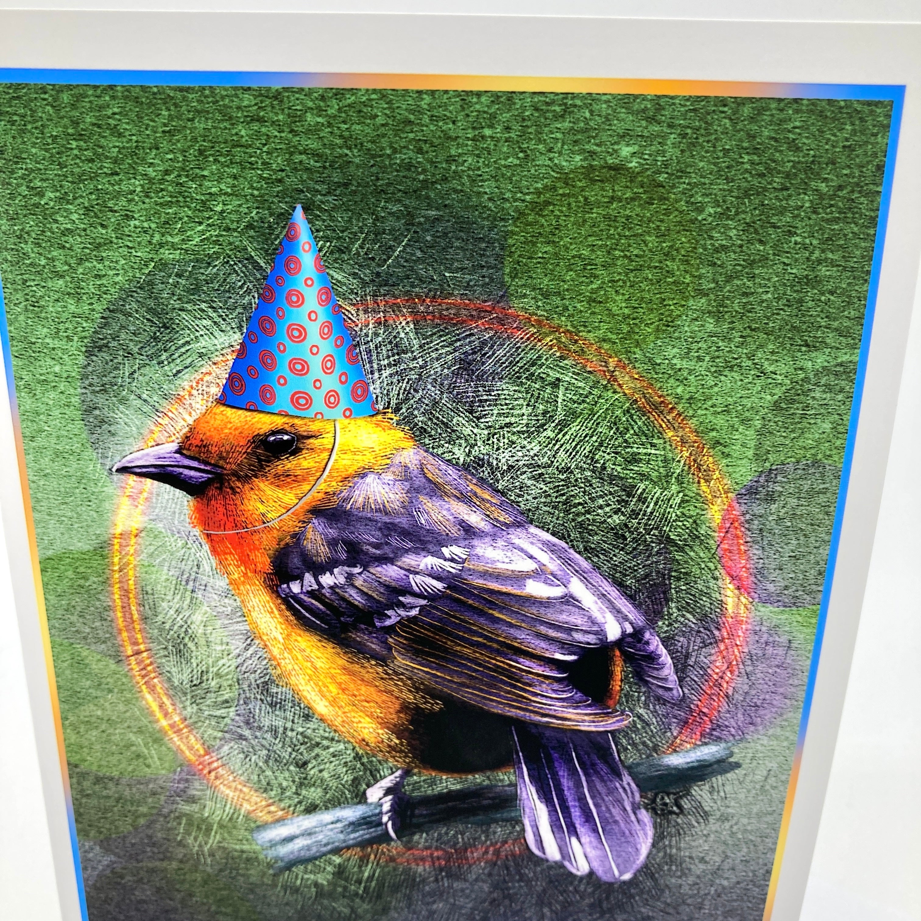 A colorful art print depicting an orange and black bird perched on a branch, wearing a blue party hat with red polka dots, set against a textured green background with circular graphic elements.