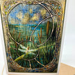 Closeup of greeting card featuring art nouveau styling around a dragonfly. Dominant colors are tans, greens, and browns.