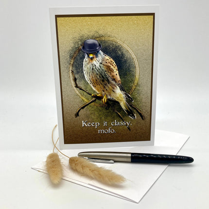 A greeting card featuring a detailed illustration of a kestrel wearing a small black bowler hat, perched on a branch with the text 'Keep it classy. mofo.
