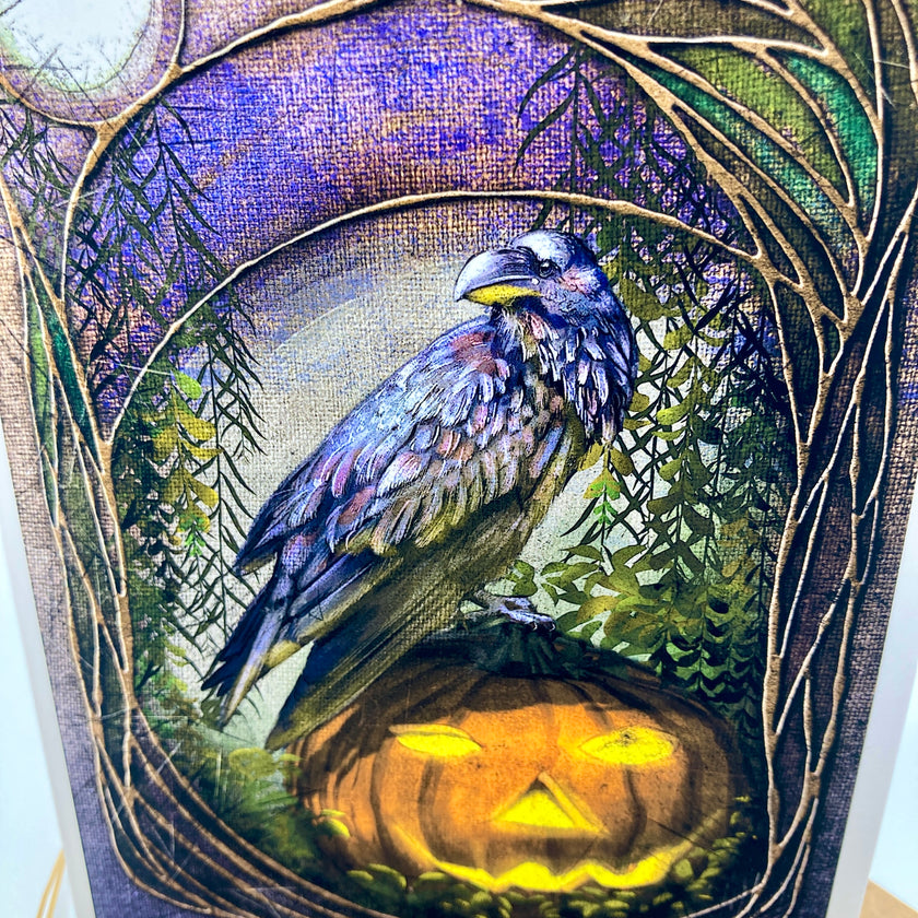 A square art print or card featuring a detailed illustration of a raven perched above a glowing jack-o'-lantern, framed by a circular vine border against a purple and green textured background.