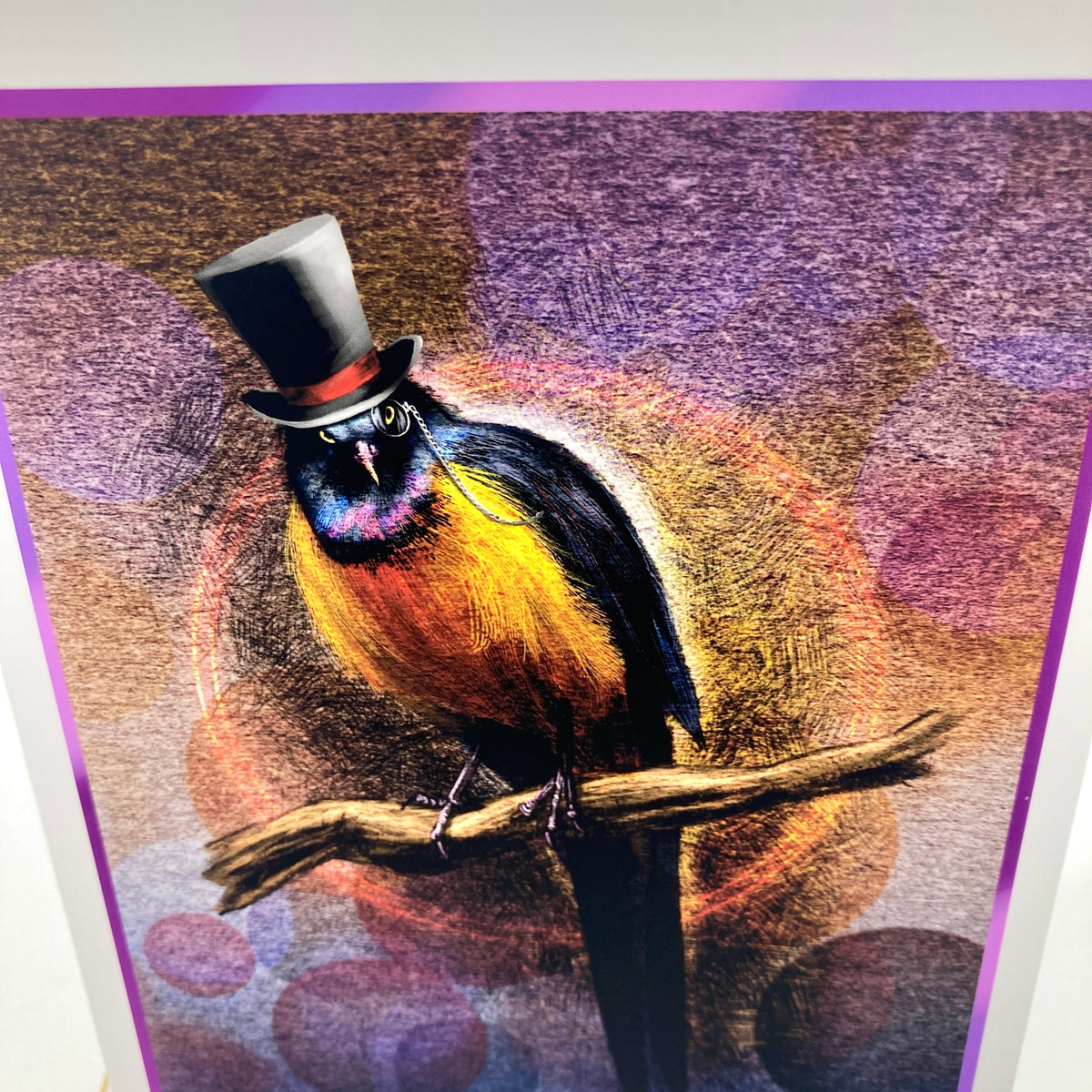 A colorful art greeting card closeup featuring a bird perched on a branch, wearing a black top hat and glasses, with a vibrant yellow, orange, and blue body against a purple and brown textured background.
