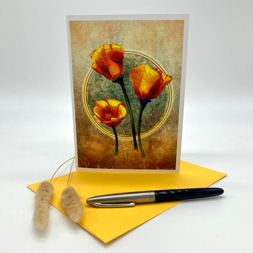 A vertical greeting card with a vintage-style illustration of three orange poppies on a textured beige and brown background, displayed standing upright on a yellow envelope with a black and silver pen and two dried bunny tail stems on a white studio background.