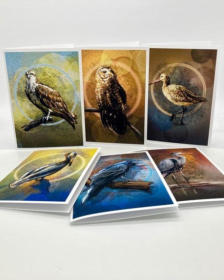 A set of bird-themed art cards displayed on a white surface, showing both upright and angled views of cards featuring painted birds including an osprey, owl, sandpiper, and others.