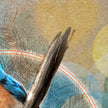 A closeup of a print featuring a stick and a circular textural detail.