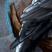 Close-up of a bird's wing with detailed feathers on a textured surface