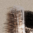 Abstract art with brown and black brush strokes on a textured beige background