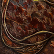 Close-up of a textured fabric with leaf patterns and a branch.