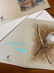 Card with a bird illustration on a wooden surface