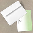 White envelope with a green card on a beige background