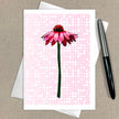 Greeting card with a pink flower illustration on a polka dot background, pen to the side.