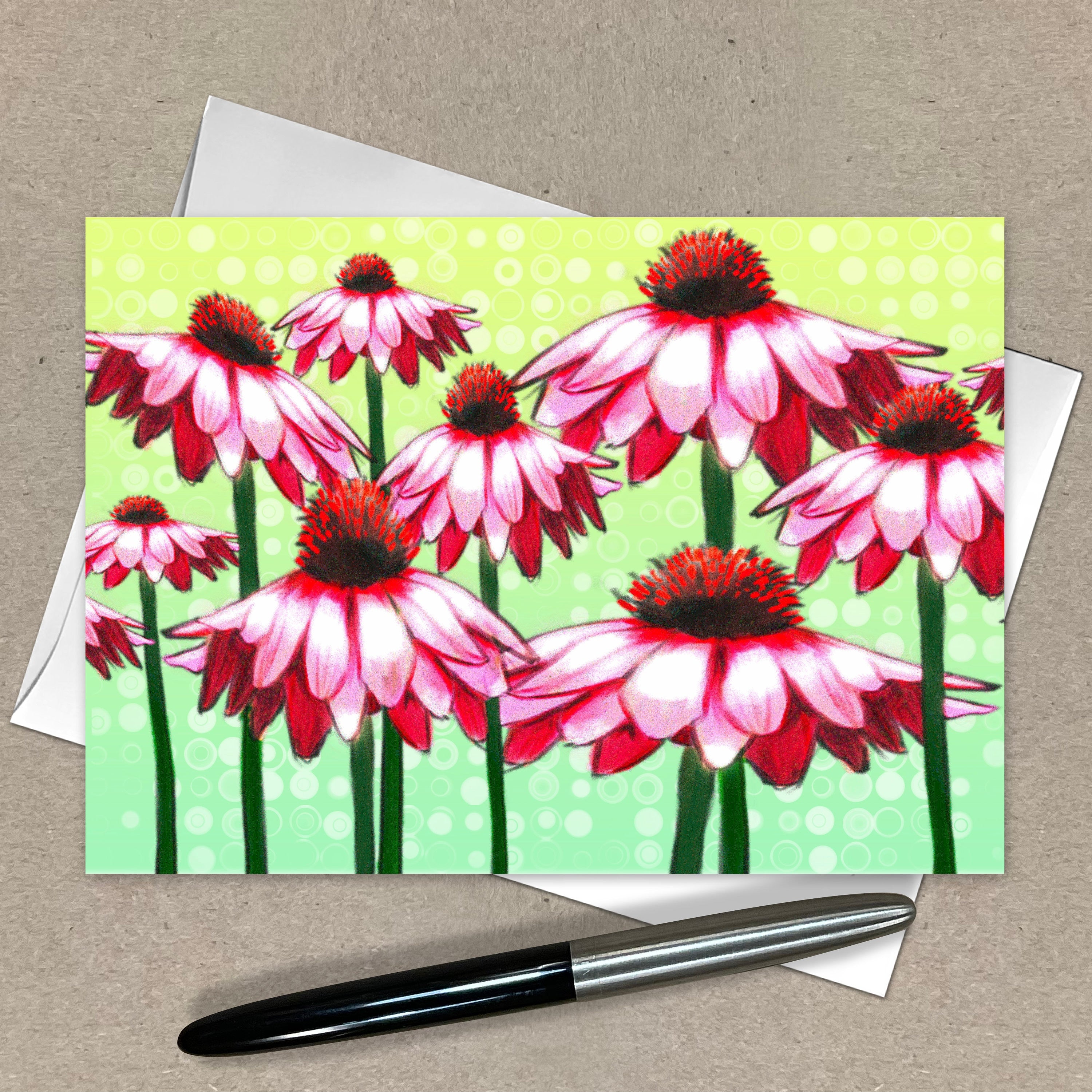Card with pink and red flower design on a green background, with a pen and envelope on a beige surface.