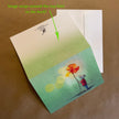 Greeting card with a colorful illustration of a mouse holding a flower, on a brown background.