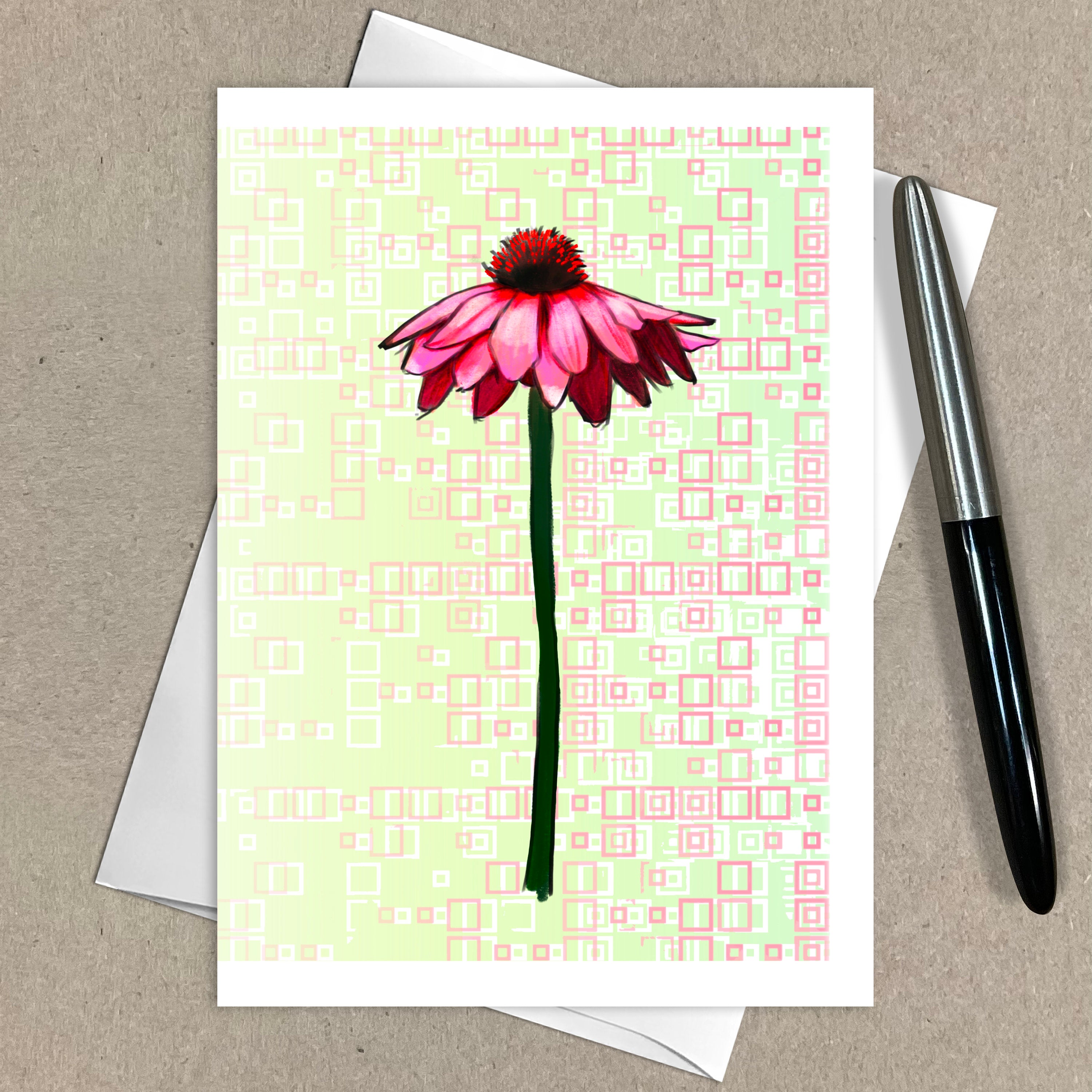 Greeting card with pink flower design on a patterned background, accompanied by an envelope and pen.