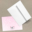 White envelope and pink card with a brand logo on a beige background