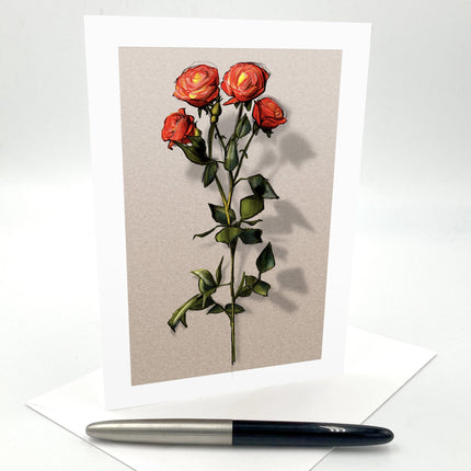 Greeting card with red roses on a beige background, accompanied by a pen.