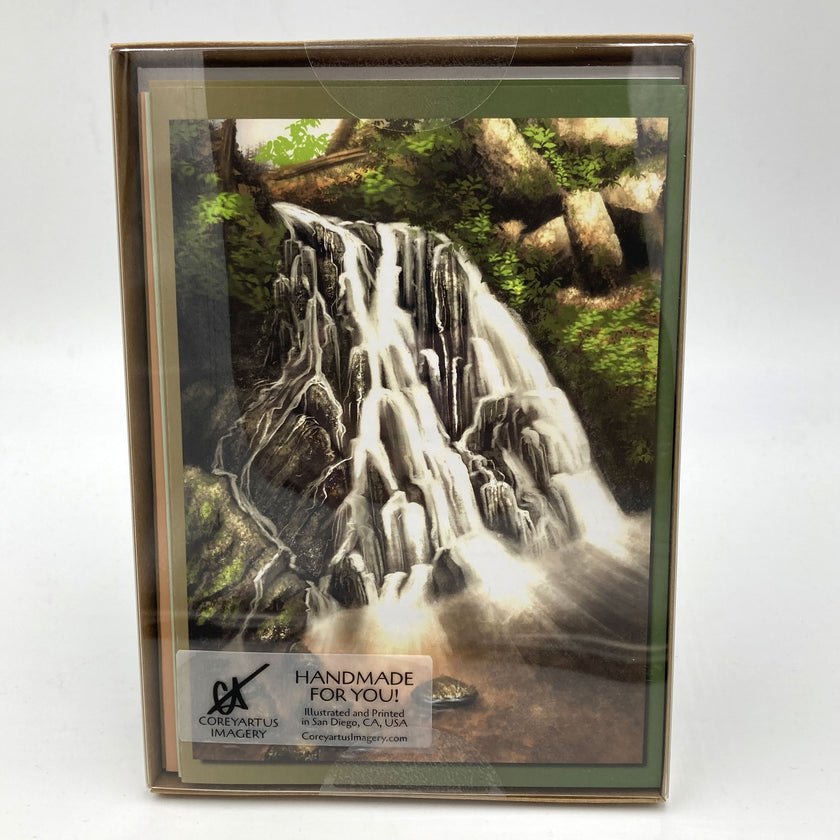 Package of greeting cards with top card featuring a waterfall with trees and greenery on a white background