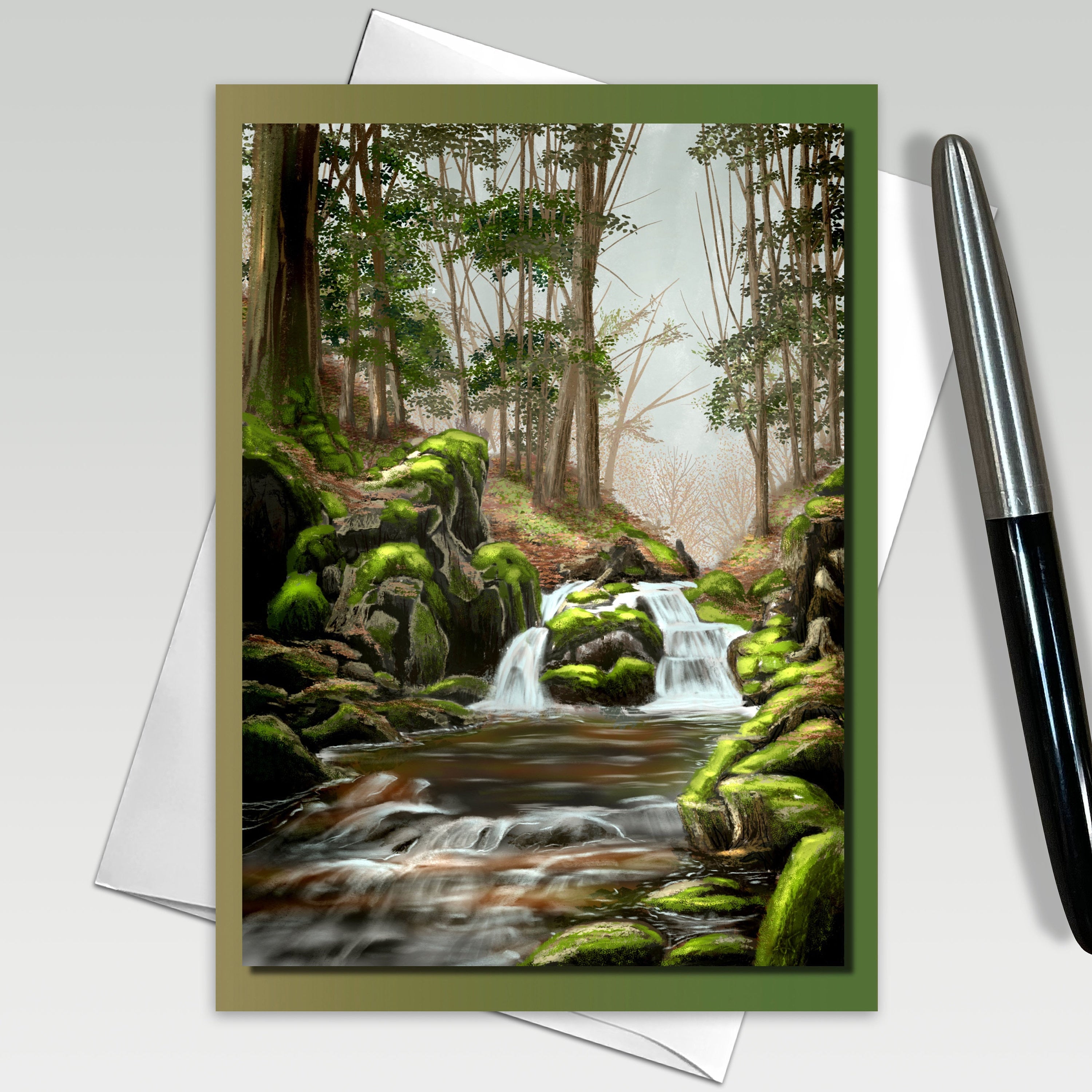 Greeting card with a forest scene featuring a stream and waterfall, with a pen on the side.