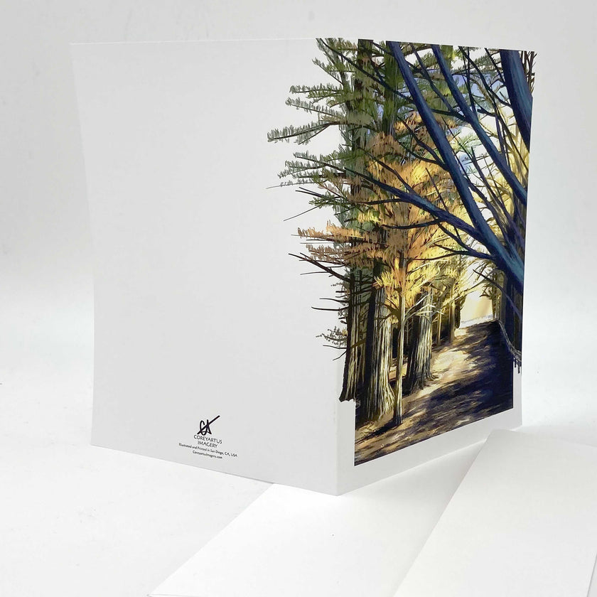 Splayed-open greeting card featuring artwork of a forest scene on a white background