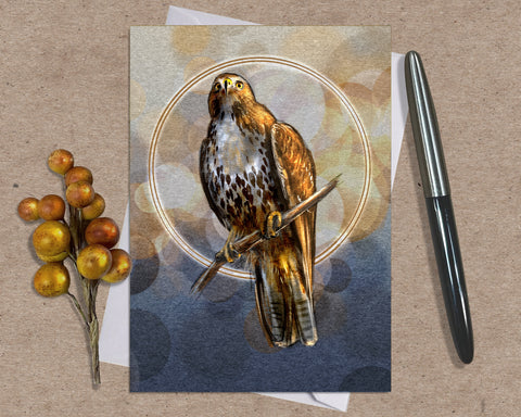 Greeting card with a hawk illustration on a textured surface with a pen and berries.