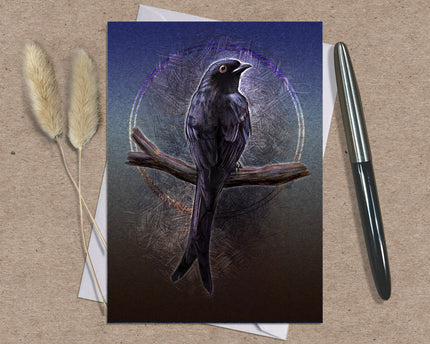 Greeting card with a bird illustration on a brown surface with a pen and dried plants.