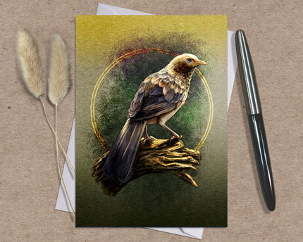 Greeting card with a bird illustration on a textured surface with a pen and dried plants.