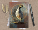 Card with a quail illustration on a textured surface with a pen and dried plants.