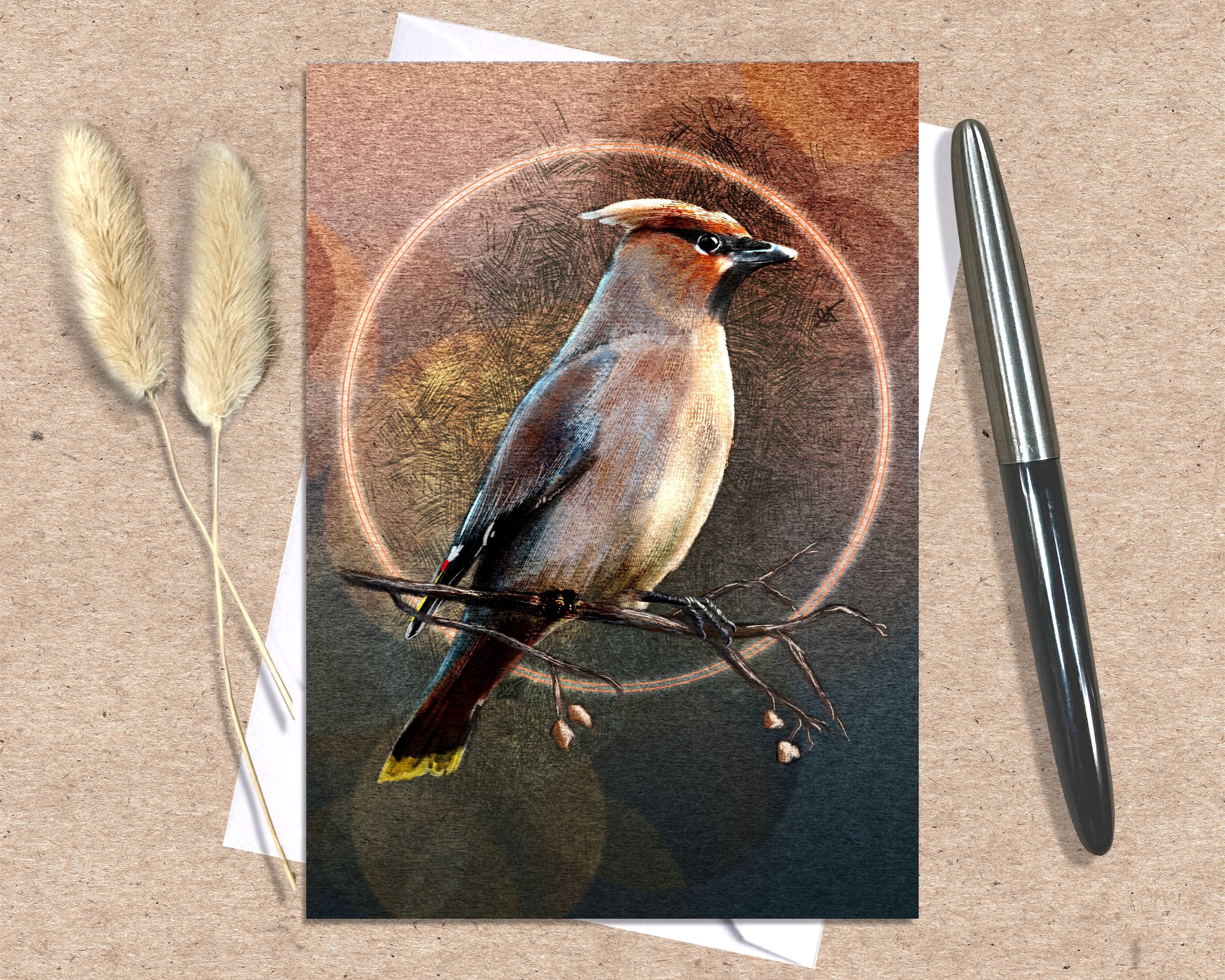 Greeting card with a bird illustration on a brown background, accompanied by a pen and dried plants.