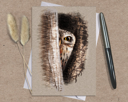 Greeting card with owl illustration on a textured surface with a pen and dried plants.