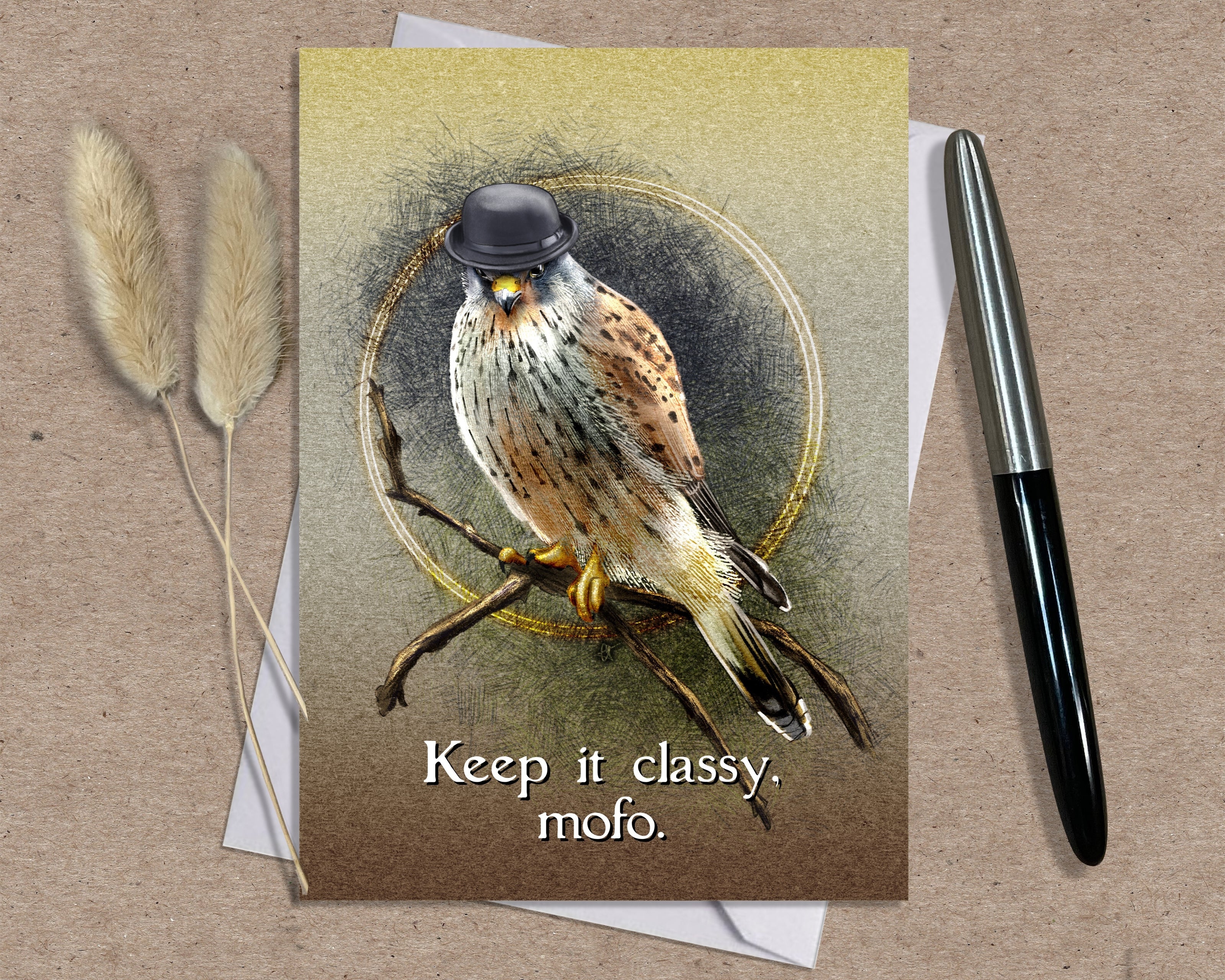 Greeting card with a bird illustration and text 'Keep it classy, mofo.' on a textured surface. The kestral wears a black bowler hat.