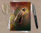 Greeting card with a bird illustration on a textured surface with a pen and dried plants.