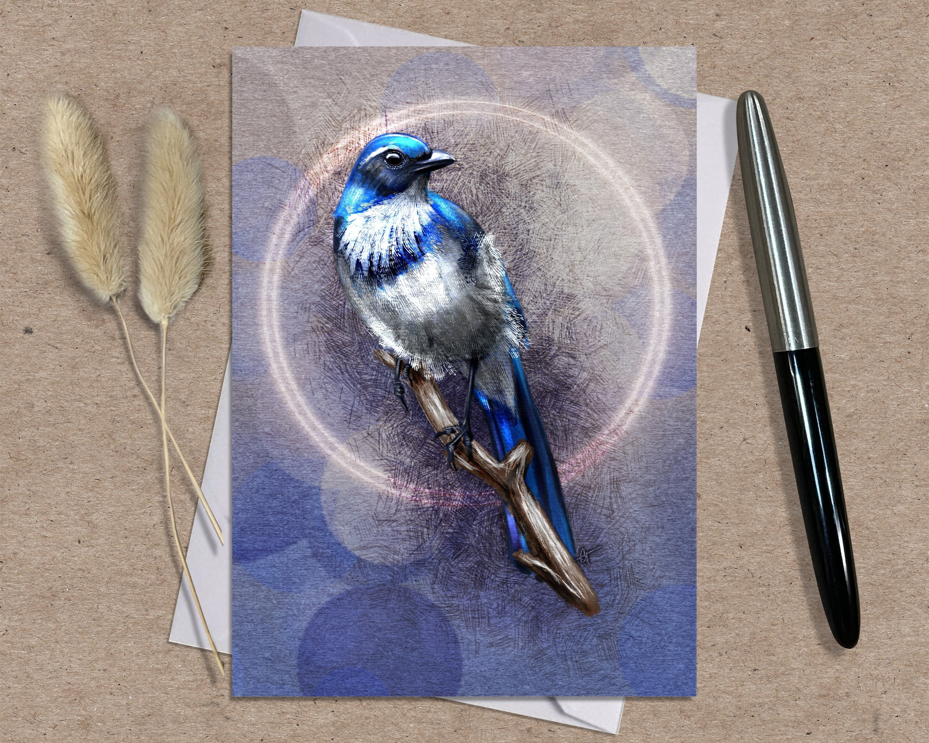 Greeting card with a blue bird illustration on a textured surface with a pen and dried plants.
