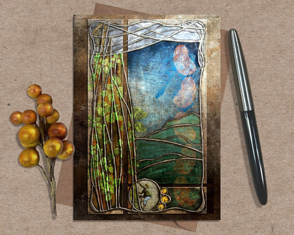 Decorative greeting card with nature-themed design on a textured surface with a pen and decorative branch.