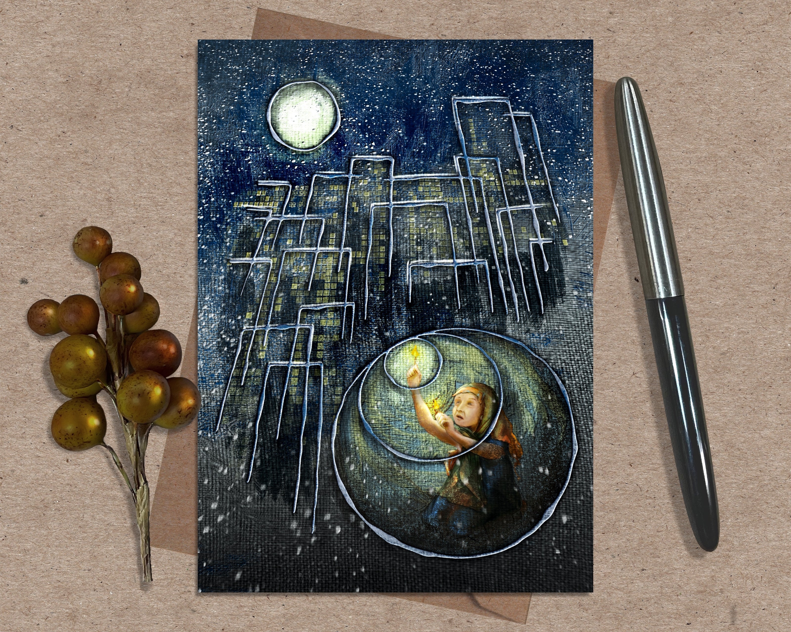 Greeting card with a fantasy design of a child holding a match, surrounded by chairs and a moonlit sky, on a textured surface with a pen and decorative elements.
