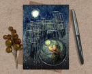 Greeting card with a fantasy design of a child holding a match, surrounded by chairs and a moonlit sky, on a textured surface with a pen and decorative elements.