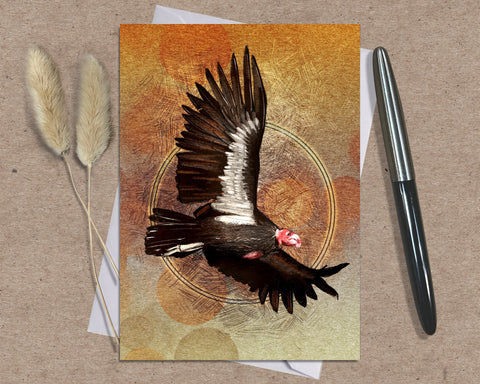 Greeting card with a bird design on a textured surface with a pen and dried plants.