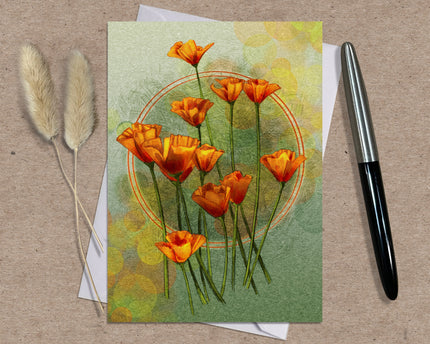 Greeting card with orange flowers on a textured surface with a pen and dried plants.