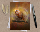 Greeting card with a bird illustration on a textured surface with a pen and dried plants.