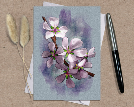 Greeting card with floral design on a textured surface with a pen and dried plants.