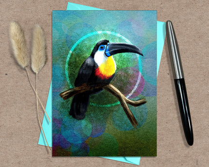 Card with a toucan illustration on a textured surface with a pen and dried plants.