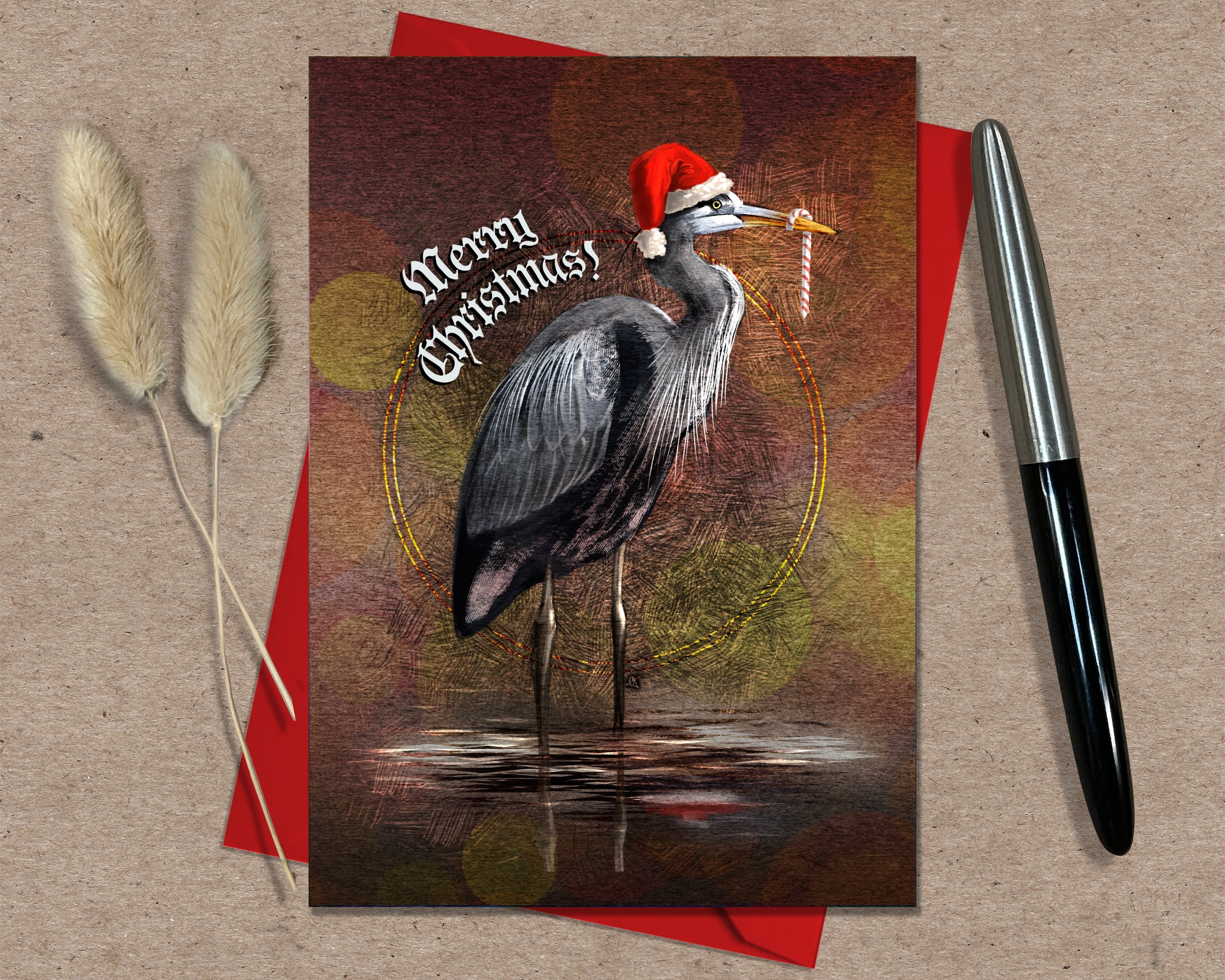 Christmas card with a heron wearing a Santa hat on a red envelope with a pen and decorative elements.