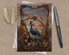 Decorative card with a bird illustration on a textured surface with a pen and dried plants.