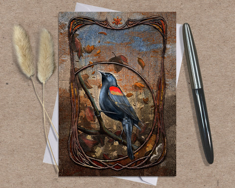 Decorative card with a bird illustration on a textured surface with a pen and dried plants.